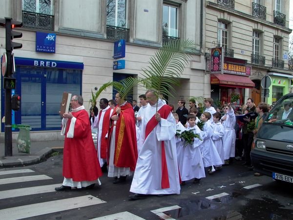 Mars : Dimanche des Rameaux. Les paroissiens parcourent les rues de leur quartier, invitant les passants à les rejoindre. 