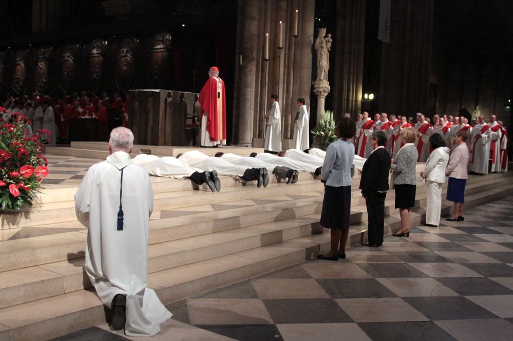 Les ordinands sont prostrés, leurs épouses sont debout derrière eux pendant (…). Photo © Yannick Boschat 