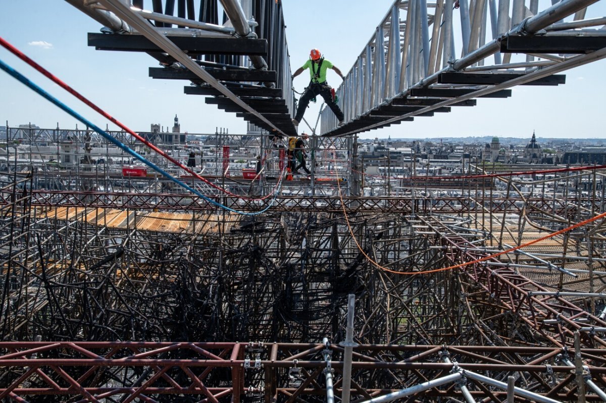 Harnaché aux poutres qui dominent l'échafaudage, un cordiste prépare sa (…). 9 juillet 2020 © Pascal Tournaire / Jarnias.